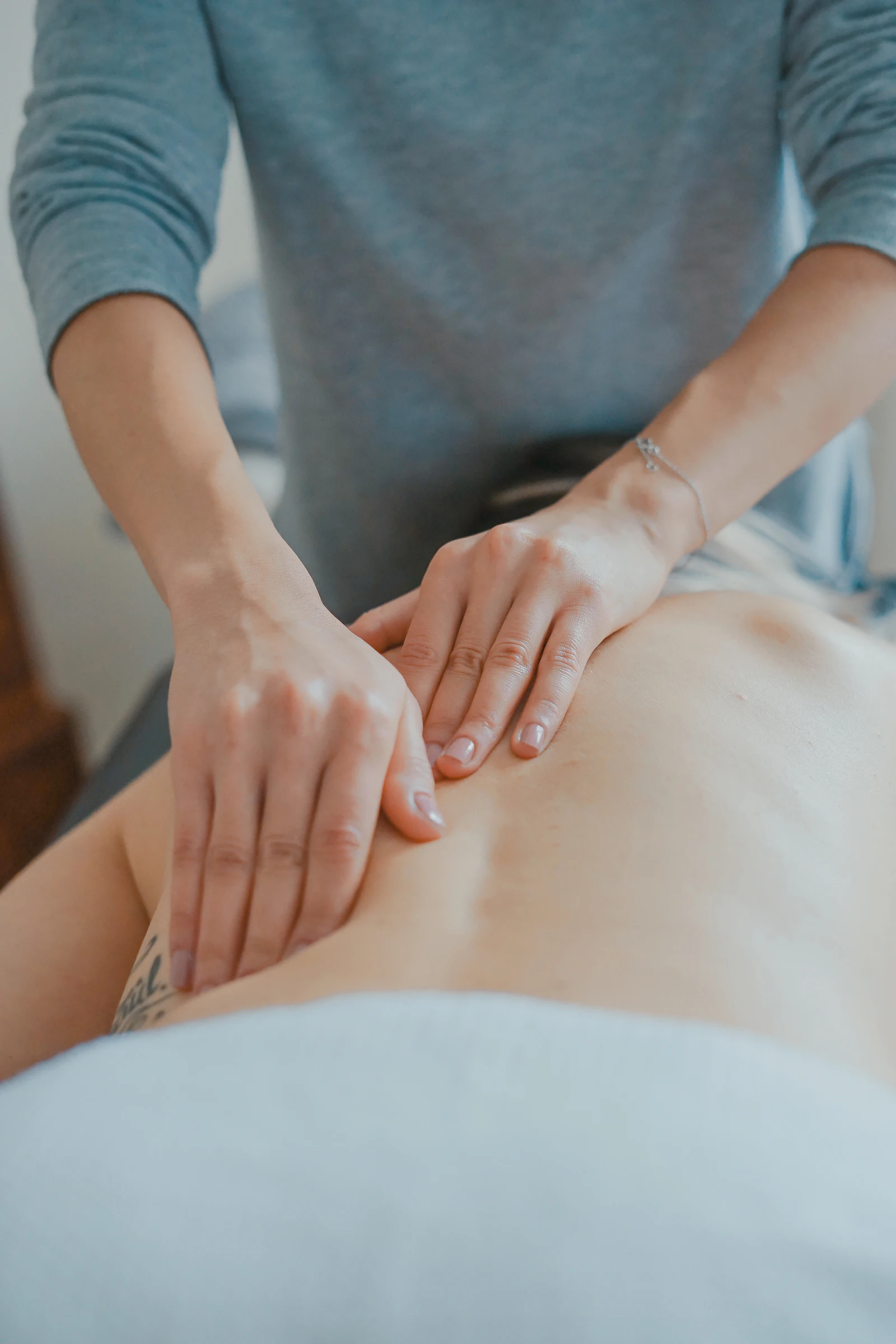 Manos de una terapeuta realizando un masaje en la espalda