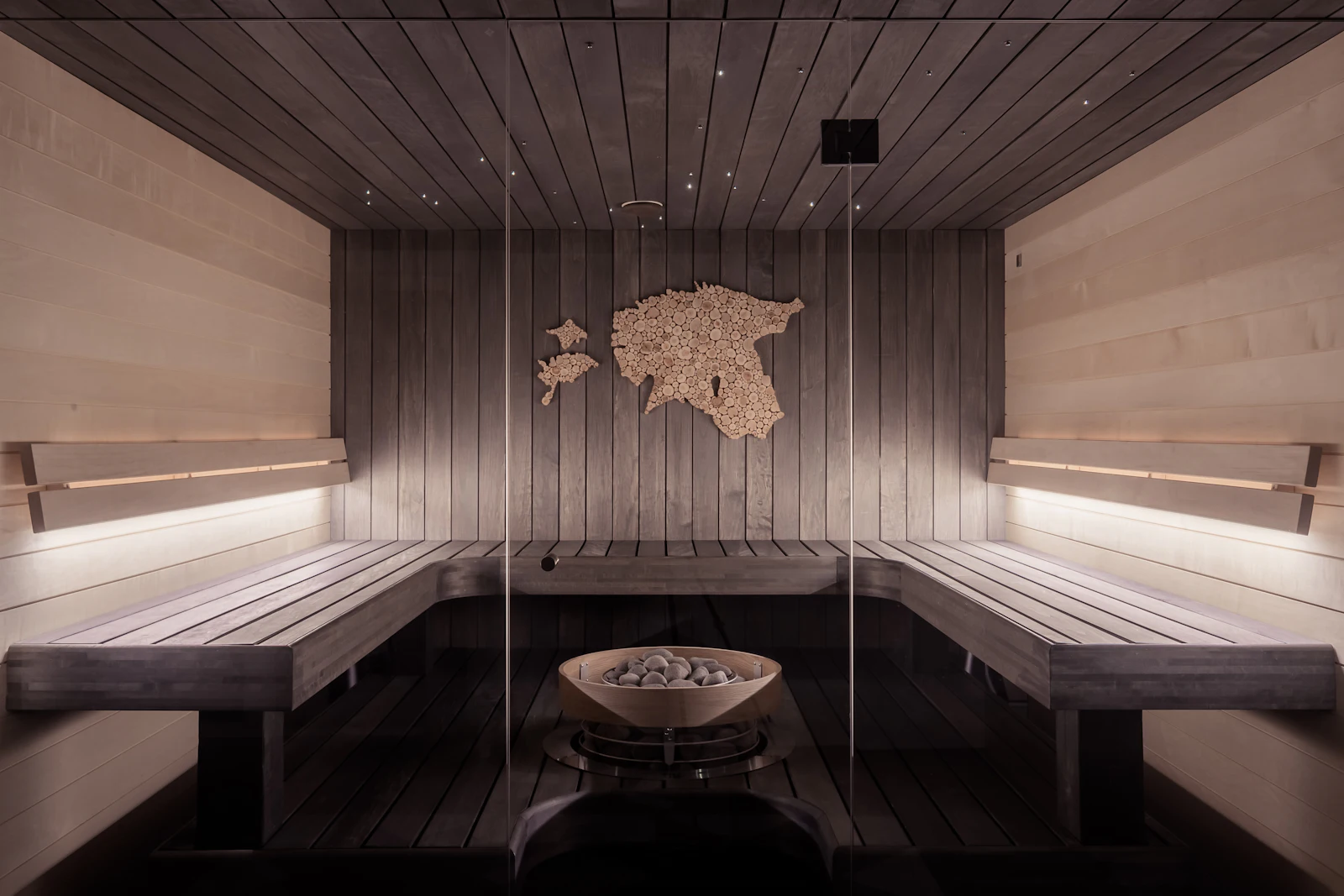 Sauna de madera con iluminación cálida y bancos de listones